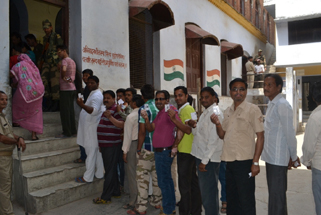 बदायूं संसदीय क्षेत्र में एक मतदान केन्द्र पर वोट डालने के लिए लाइन मेंलगे मतदाता